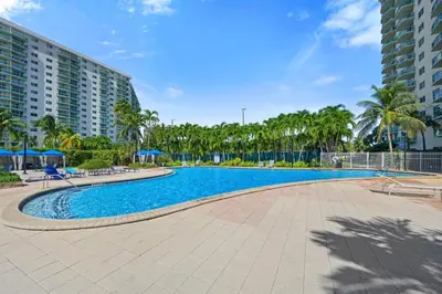 a swimming pool at a resort with palm trees at Ocean Reserve 1616 in Miami Beach