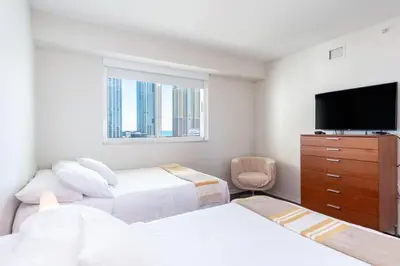a bedroom with two beds and a flat screen tv at Marina Bay 1103 in Miami Beach