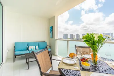 a dining room with a table and chairs and a balcony at Marina Bay 1103 in Miami Beach