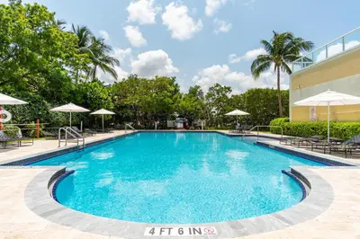 a swimming pool at a resort with chairs and umbrellas at Golden Bay 508 in Miami Beach