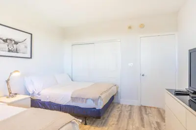 a bedroom with two beds and a flat screen tv at Golden Bay 606 in Miami Beach