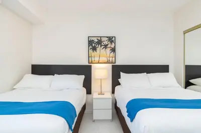 a bedroom with two beds and a lamp in it at Golden Bay 1003 in Miami Beach