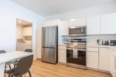 a kitchen with white cabinets and a stainless steel refrigerator at Golden Bay 502 in Miami Beach