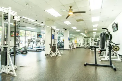 a gym with lots of machines and a ceiling fan at Ocean Reserve 1515 in Miami Beach