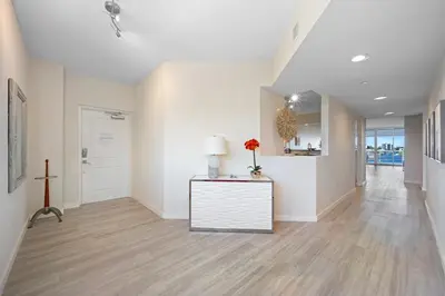 a hallway with white walls and a cross on a table at Golden Bay 509 in Miami Beach