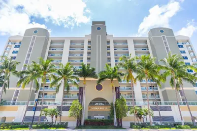 a large building with palm trees in front of it at Golden Bay 509 in Miami Beach