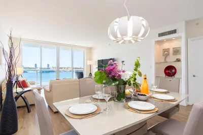 a dining room and living room with a table and chairs at Golden Bay 602 in Miami Beach
