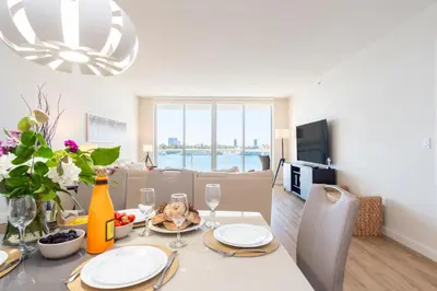 a dining room and living room with a table and chairs at Golden Bay 602 in Miami Beach