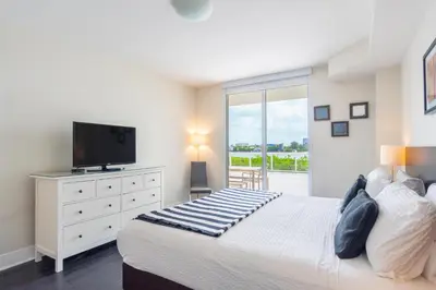 a bedroom with a large bed with a flat screen tv at Golden Bay 302 in Miami Beach