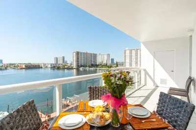 a table with a vase of flowers on a balcony at Golden Bay 707 in Miami Beach