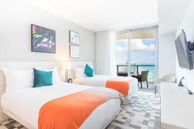 two beds in a room with a view of the ocean at Lyfe Beach Resort 3604 in Hollywood Beach