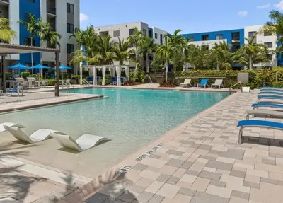 a swimming pool at a resort with chairs and palm trees at Doral 1BR w wd pool gym nr Airport MIA-17 in Miami
