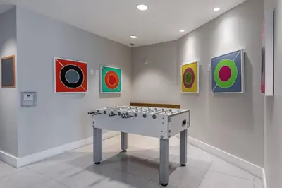 a ping pong table in a room with paintings at Doral 1BR w wd pool gym nr Airport MIA-17 in Miami