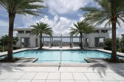 a swimming pool with palm trees in front of a building at Coral Gables 1BR w WD Pool Gym nr Shops MIA-9 in Miami