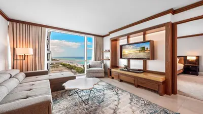 a living room with a couch and a tv and a bed at 1 Bedroom Private Residence at Carillon Miami Resort -911 in Miami Beach