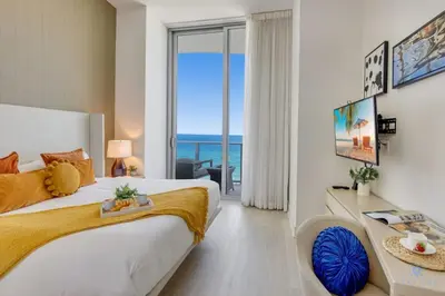 a bedroom with a large bed with a view of the ocean at Beachfront Condo Front Oceanview Balcony Pools in Hollywood