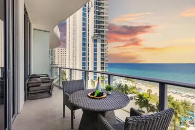 a balcony with a table and chairs and the ocean at Beachfront Condo Front Oceanview Balcony Pools in Hollywood