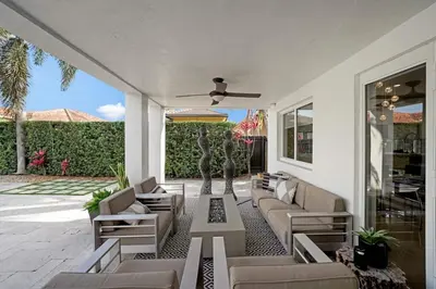 a patio with couches and a statue in the background at Luxury home w pool by PMI in Miami