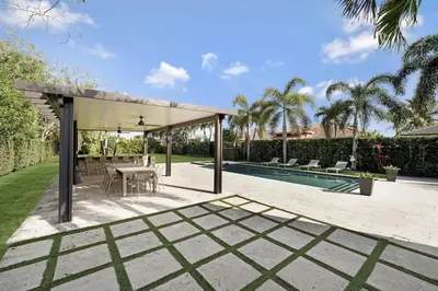 a patio with a table and chairs and a pool at Luxury home w pool by PMI in Miami