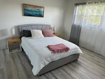 a bedroom with a bed with white sheets and pink pillows at Ft Lauderdale Jewel in Fort Lauderdale