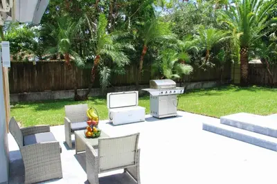 a backyard with a grill and a table with chairs at Fox Private Resort-Heated Pool, Spa-Downtown&Beach in Fort Lauderdale