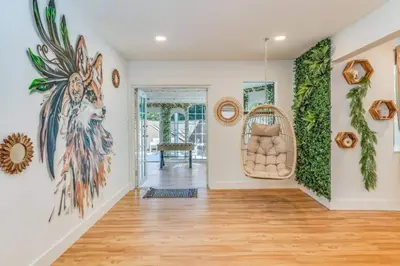 a living room with a large painting on the wall at Fox Garden-Heated Pool-Spa- Boho-Downtown & Beach in Fort Lauderdale