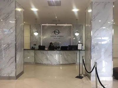 a woman sitting at a counter in a lobby at Beautiful Apartment in Sunny Isles STR-01432 in Miami Beach