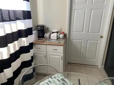 a small kitchen with a table and a door at Private Rooms close to Miami Airport - Free parking - 02 in Miami