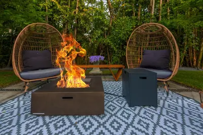 a fire pit in a yard with two chairs and a table at Fascinating Luxe Two-Level Villa BY THE GLAMHOMES in Biscayne Park