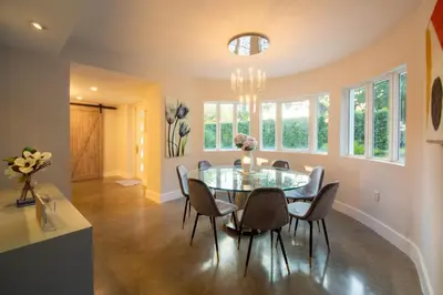 a dining room with a glass table and chairs at Fascinating Luxe Two-Level Villa BY THE GLAMHOMES in Biscayne Park