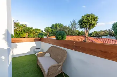 a balcony with a chair and a view of a roof at Fascinating Luxe Two-Level Villa BY THE GLAMHOMES in Biscayne Park