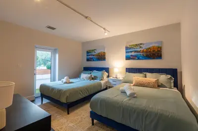 a bedroom with two beds and a window at Fascinating Luxe Two-Level Villa BY THE GLAMHOMES in Biscayne Park