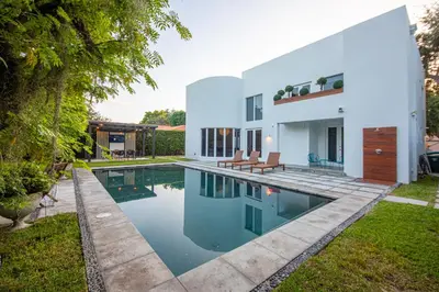 a house with a swimming pool in front of it at Fascinating Luxe Two-Level Villa BY THE GLAMHOMES in Biscayne Park