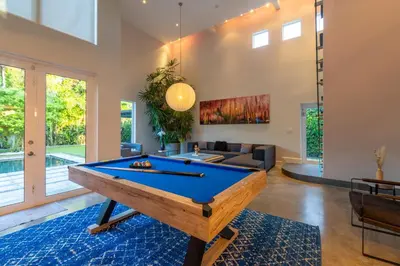 a living room with a pool table at Fascinating Luxe Two-Level Villa BY THE GLAMHOMES in Biscayne Park