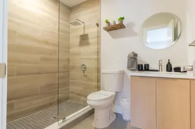 a bathroom with a toilet and a glass shower at Mega Fun Villa Northwest Miami BY THE GLAMHOMES in Miami
