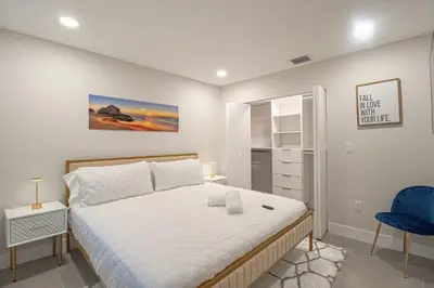 a bedroom with a bed and a blue chair at Mega Fun Villa Northwest Miami BY THE GLAMHOMES in Miami