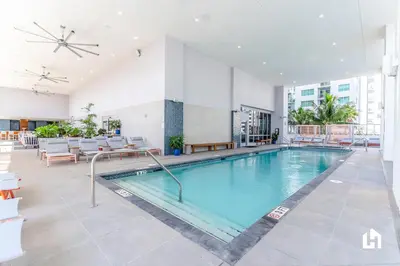 a pool in a hotel lobby with tables and chairs at Downtown Miami Condos by Lua Host in Miami