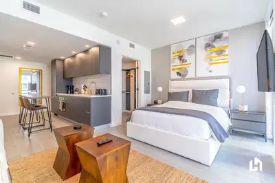 a bedroom with a white bed and a kitchen at Downtown Miami Condos by Lua Host in Miami