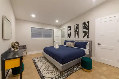 a bedroom with a bed and a desk and a door at Super Fun Villa Game Room BY THE GLAMHOMES in North Miami Beach