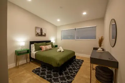 a bedroom with a bed and a desk in it at Super Fun Villa Game Room BY THE GLAMHOMES in North Miami Beach