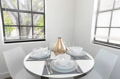 a white table with plates and a vase on it at Lovely Apartment Near Brickell 2 in Miami