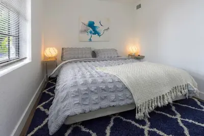 a bedroom with a large bed with a blue rug at Lovely Apartment Near Brickell 2 in Miami