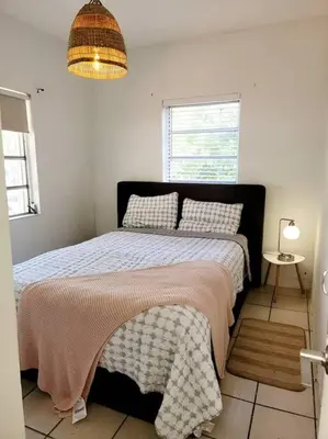 a bedroom with a bed with a blanket and a window at Tropical Charm Little Havana Calle Ocho 3 in Miami