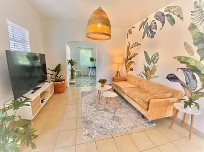 a living room with a couch and a flat screen tv at Tropical Charm Little Havana Calle Ocho 2 in Miami