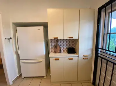 a kitchen with a white refrigerator and white cabinets at Tropical Charm Little Havana Calle Ocho 2 in Miami