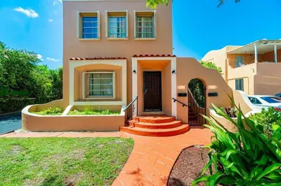 a house with a staircase leading to the front door at Tropical Charm Little Havana Calle Ocho 2 in Miami