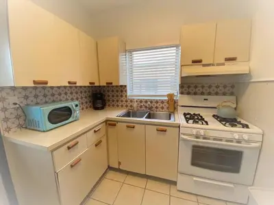 a kitchen with a microwave and a stove top oven at Tropical Charm Little Havana Calle Ocho 2 in Miami