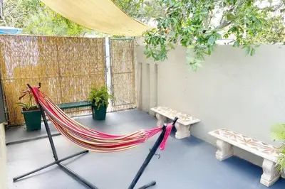 a hammock on a patio with benches and a fence at Amazing & cozy Duplex near Zoo Miami ! in Miami