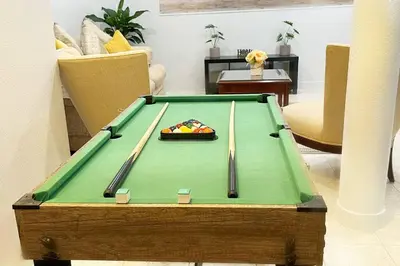 a pool table with two cuesticks on top of it at Amazing & cozy Duplex near Zoo Miami ! in Miami