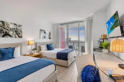 a hotel room with two beds and a window at Apartment w Balcony Gym Near Beach in Hallandale Beach